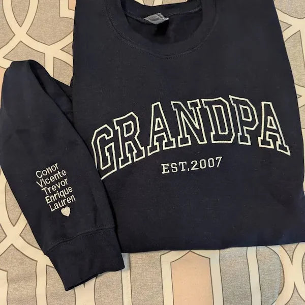 Black sweatshirt with 'GRANDPA EST.2007' text on a patterned surface